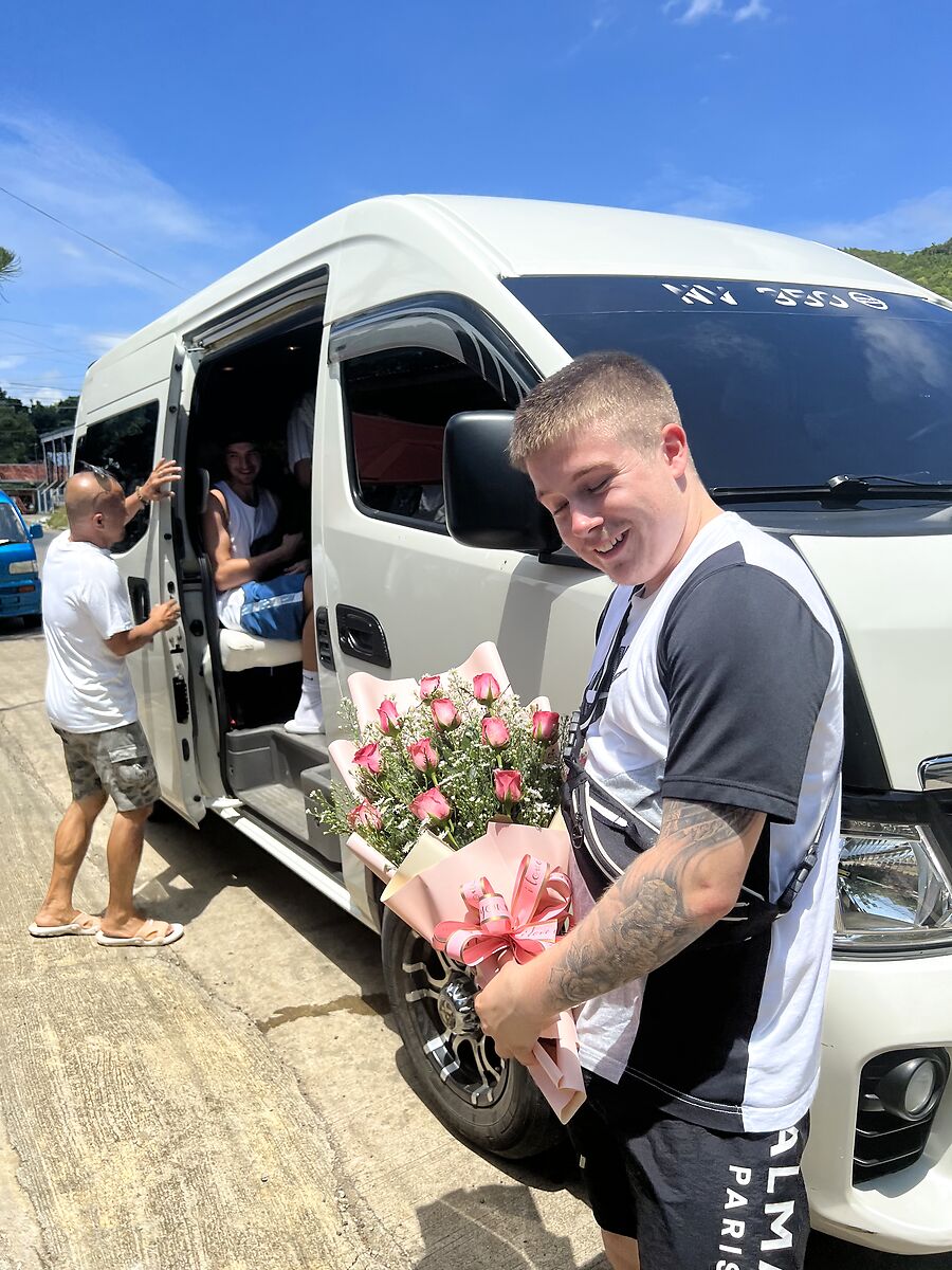 Happy guests boarding the white JM Van Rentals tour van on a sunny day